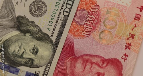rotation of China yuan or renminbi rmb against US dollar bill of 100 banknotes. Chinese and USA trade war.