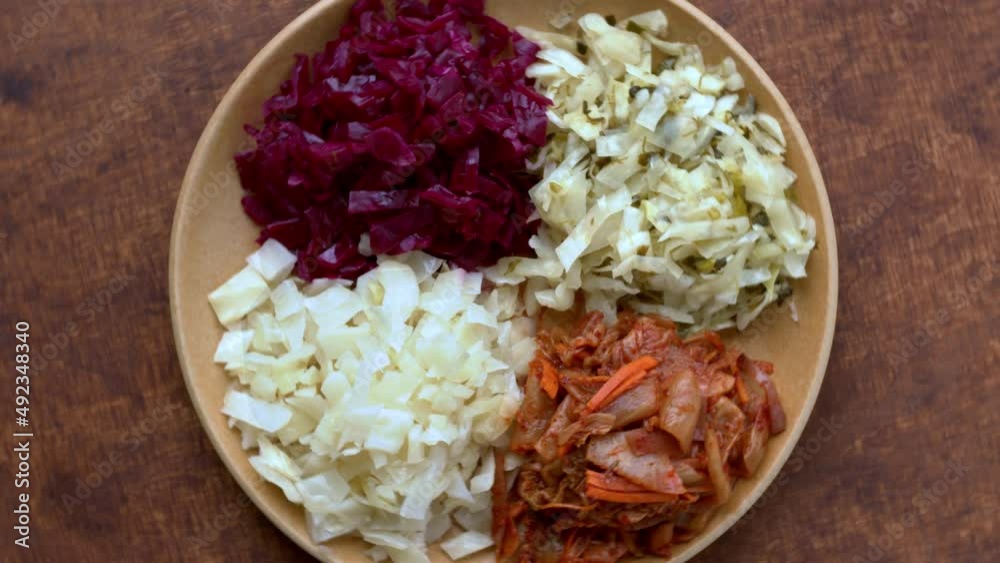 Set of fermented cabbage salads sauerkraut. Variety of different preserved cabbage vegetables. Top view, table spin, zoom-in. Set of fermented cabbage salads sauerkraut. Variety of different preserved cabbage vegetables. Top view, table spin, zoom-in.