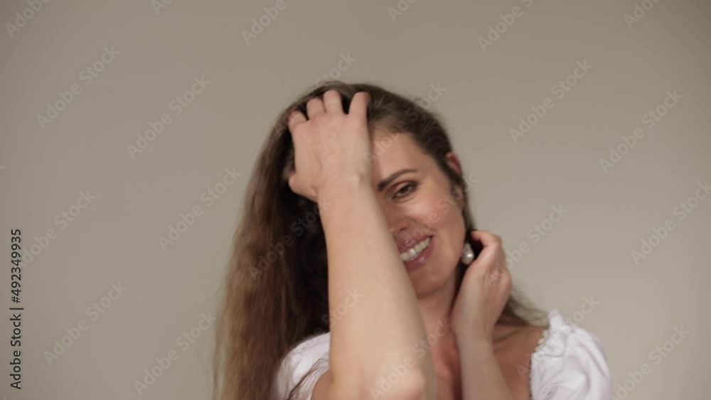 Beautiful woman in the background. Close-up of the face,. Cute woman with curly hair posing for the camera. Beautiful woman in the background. Close-up of the face,. Cute woman with curly hair posing for the camera.