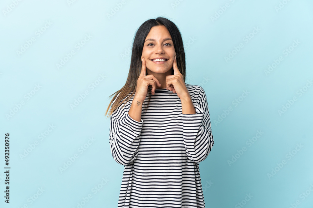 Caucasian girl isolated on blue background smiling with a happy and pleasant expression