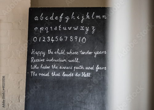 Vintage school Victorian chalk board with alphabet and numbers written on it.