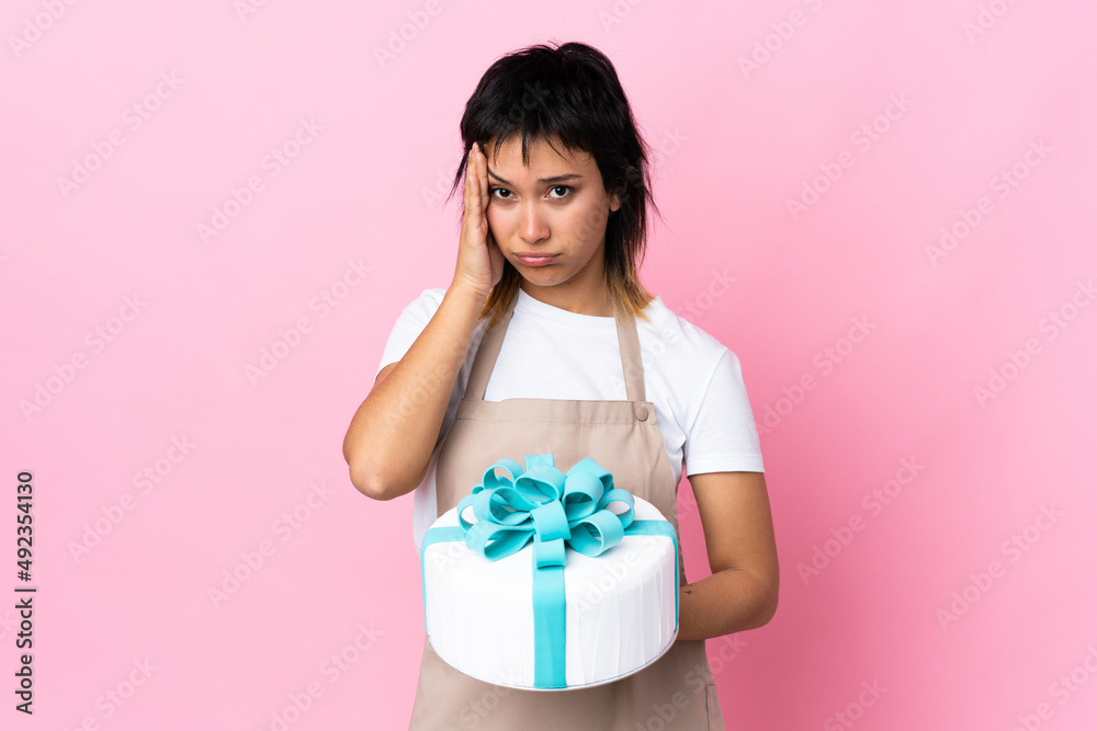 Uruguayan Pastry chef holding a big cake over isolated pink background unhappy and frustrated with something. Negative facial expression Uruguayan Pastry chef holding a big cake over isolated pink background unhappy and frustrated with something. Negative facial expression