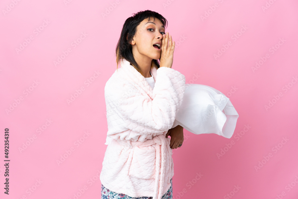 Young Uruguayan woman in pajamas over isolated pink background whispering something Young Uruguayan woman in pajamas over isolated pink background whispering something