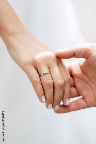 the bride and groom tenderly hold hands