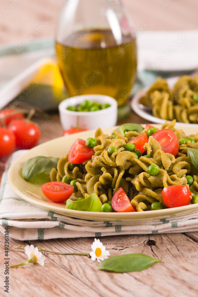 Fusilli pasta with cherry tomatoes and peas.
