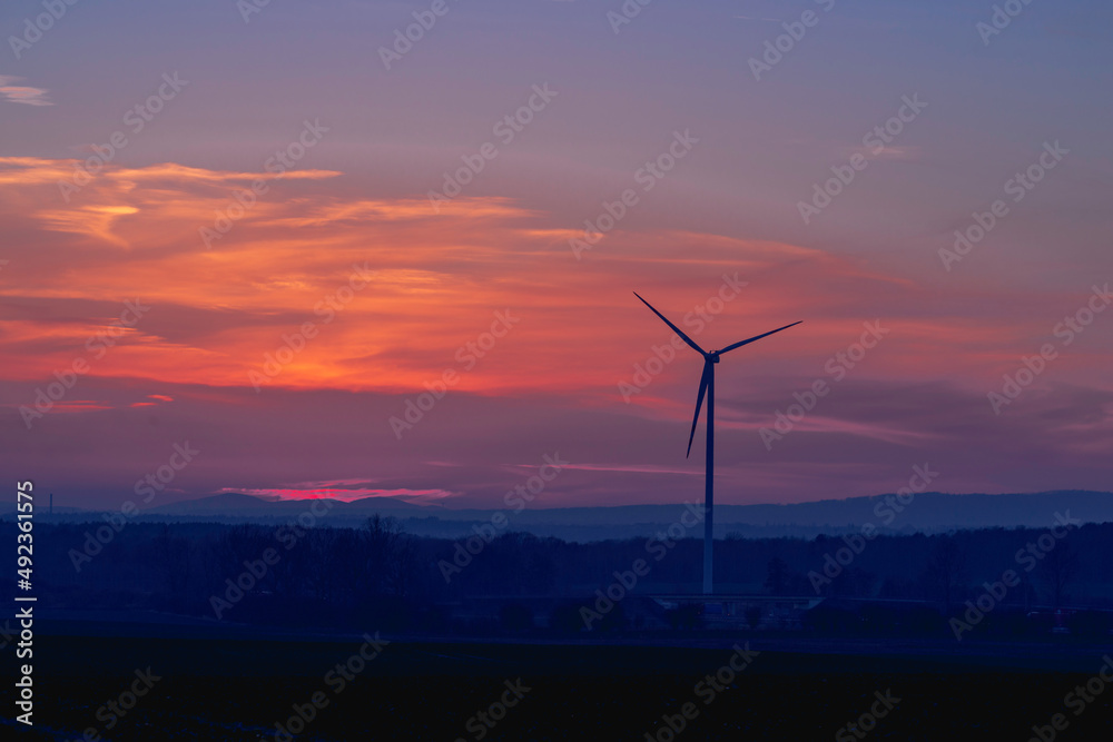 Obraz premium Wiatrowe elektrownie na tle wieczornego nieba.