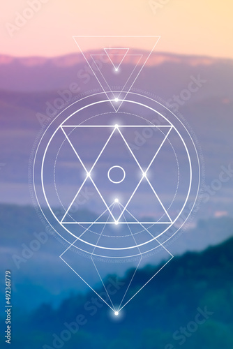 Sacred geometry spiritual new age futuristic illustration with interlocking circles, triangles and glowing particles in front of blurry natural photographic background