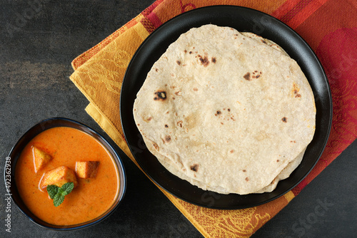Tandoori Roti whole wheat flat bread with Indian curry butter chicken and butter paneer . Indian roti or chapati  photo
