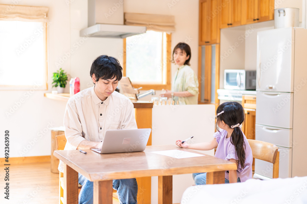 テレワークをする夫婦と子供 テレワークをする夫婦と子供