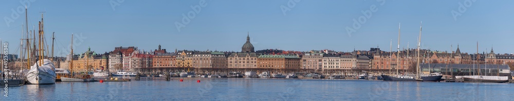 Panorama view over the bay Ladugårdsviken, piers with boats, apartment and hotel houses and a sunny winter day in Stockholm