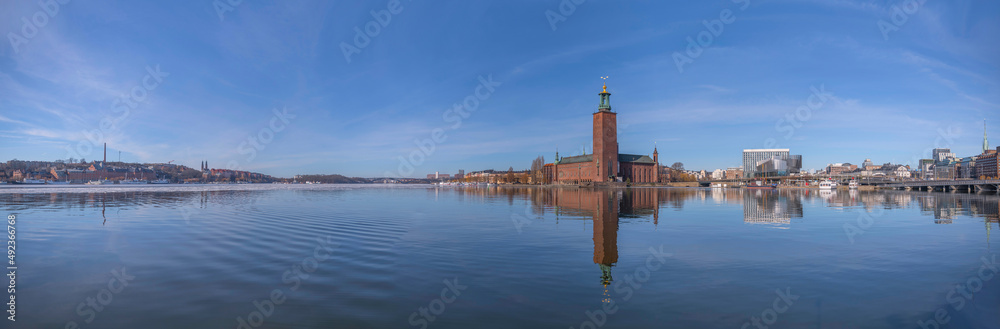 Panorama view over the bay Riddarfjärden with ice floes and Town City Hall, waterfront with boats, offices and the central station Centralstationen a sunny spring day in Stockholm