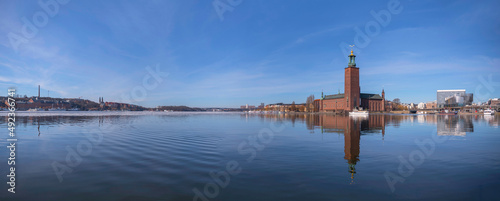 Panorama view over the bay Riddarfjärden with ice floes and Town City Hall, waterfront with boats, offices and the central station Centralstationen a sunny spring day in Stockholm