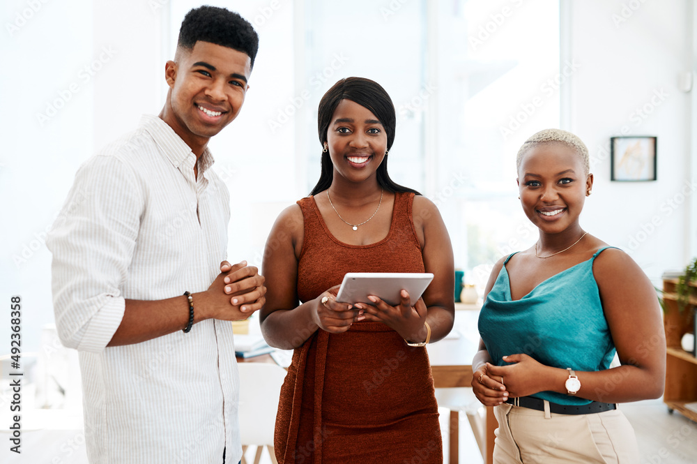 Obraz premium We give our best because our clientd deserve the best. Portrait of a group of young businesspeople using a digital tablet together in a modern office.
