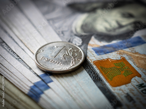 Russian rouble coin on a hundred dollar bill. Russia and USA money. Ruble and dollars. Currency exchange. Economic crisis. War in Ukraine effect. Financial analytics. Investment and banking. Business 