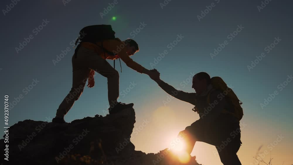 Family team success.Silhouette of group people.Climb to the top of mountain.Helping hand family victory.Teamwork concept.Business handshake.Helping hand of business people.Teamwork is path to success