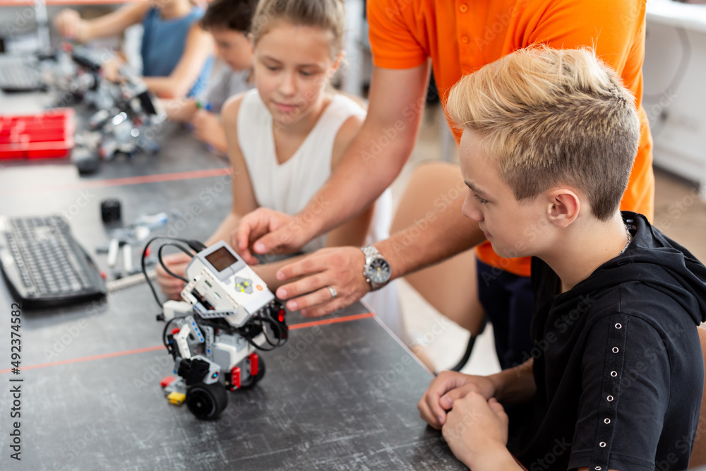 Kids working with teacher on their robot education project Kids working with teacher on their robot education project