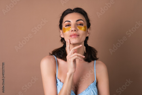 Close beauty portrait of a woman with perfect skin and natural make-up, golden patches under the eyes, to moisturize the skin and relieve puffiness of the face