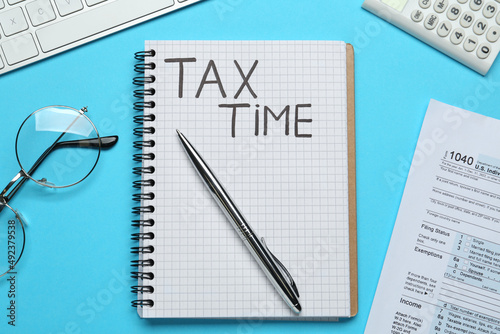 Wallpaper Mural Notebook with words Tax Time, documents, computer keyboard, calculator and glasses on light blue background, flat lay Torontodigital.ca