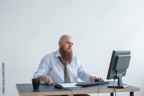 Problems for the office worker. A bald man in a white shirt sits at a desk with a computer and is stressed because of failure. A nervous breakdown.