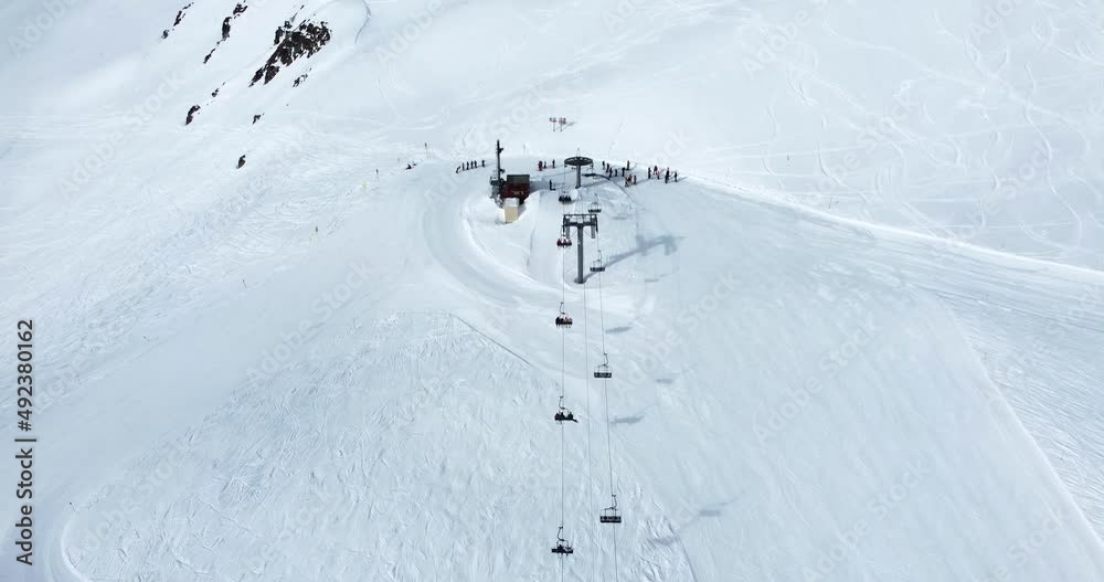 Vue aérienne en drone de l'arrivée d'un télésiège dans une station de ski en Savoie dans les Alpes en France - Aerial drone view of a ski lift arrival in the Alps, Moutains in Savoie, France 