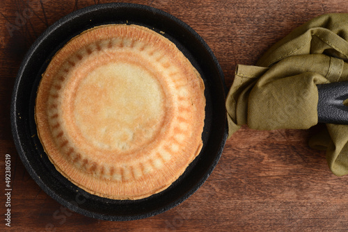 closeup pie in cast iron skillet with green napkin around handle photo