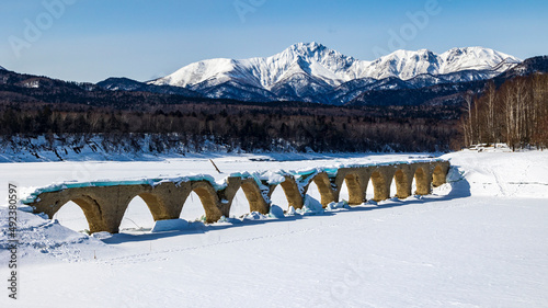 冬のタウシュベツ橋梁と冠雪したニペソツ山 photo