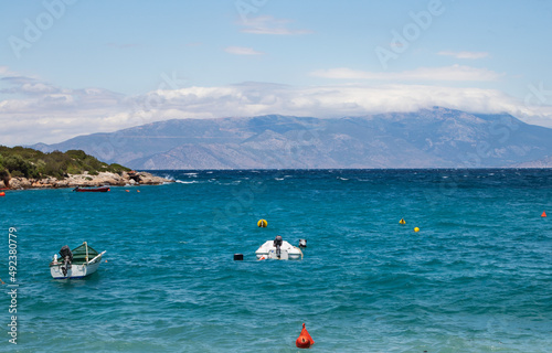 Coastline of beautiful Mediterranean sea with motor boats with thick clouds, high mountains, Greece