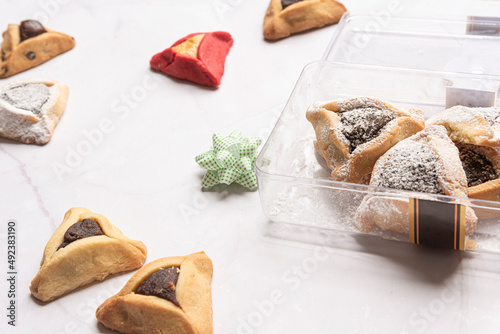 Purim celebration concept, jewish carnival holiday. Traditional hamantaschen cookies over white wooden table. High quality photo