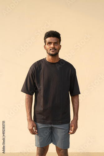 Portrait of handsome African man wearing oversized black t-shirt