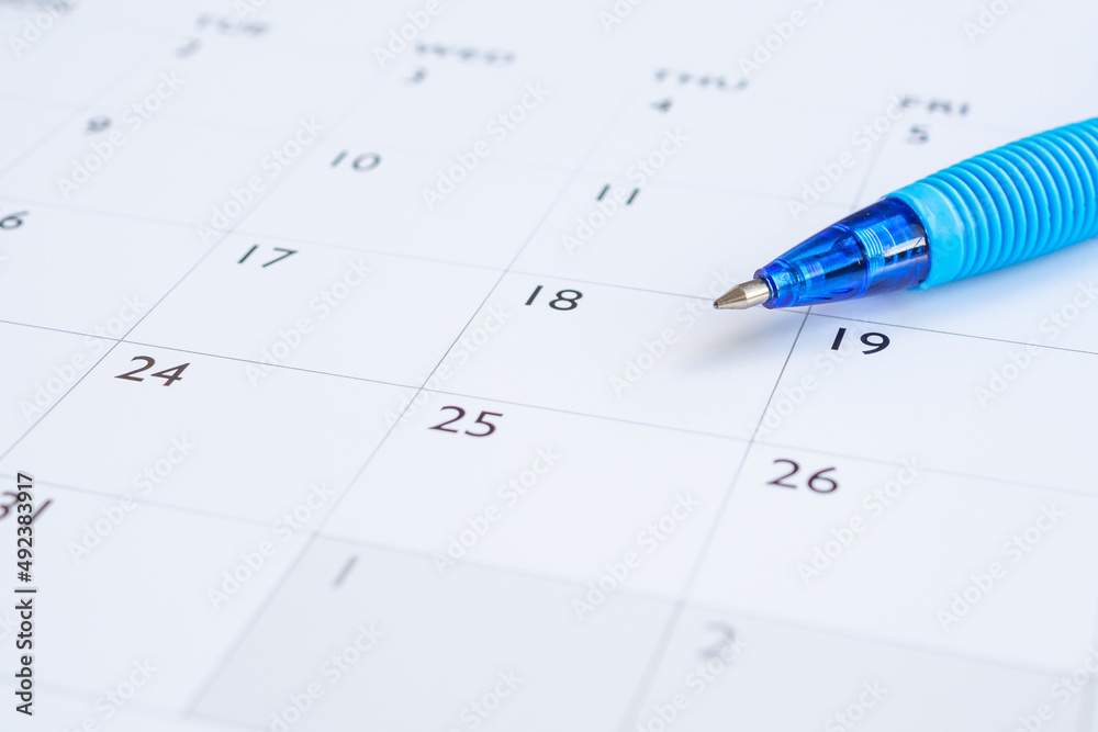 Blue pen on calendar page background business planning appointment meeting concept Blue pen on calendar page background business planning appointment meeting concept