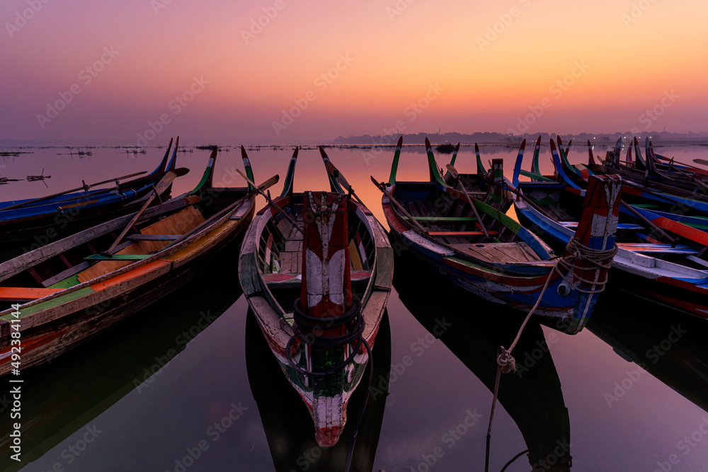 Gondora boats. A fisherman wooden boat parked under the U-Bein Bridge At sunrise. Amarapura, Mandalay, Mynmar.
