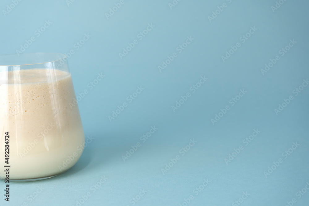 Traditional Indian mango lassi drink on a blue background. Copy space. Traditional Indian mango lassi drink on a blue background. Copy space.
