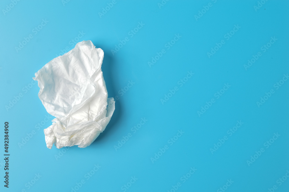 White crumpled tissue isolated on a blue background. Hygiene, healthcare and safety concept.