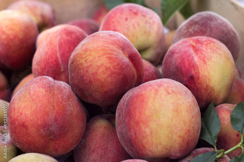 Lots of ripe peaches in a wooden box. Fruit background, healthy food Lots of ripe peaches in a wooden box. Fruit background, healthy food