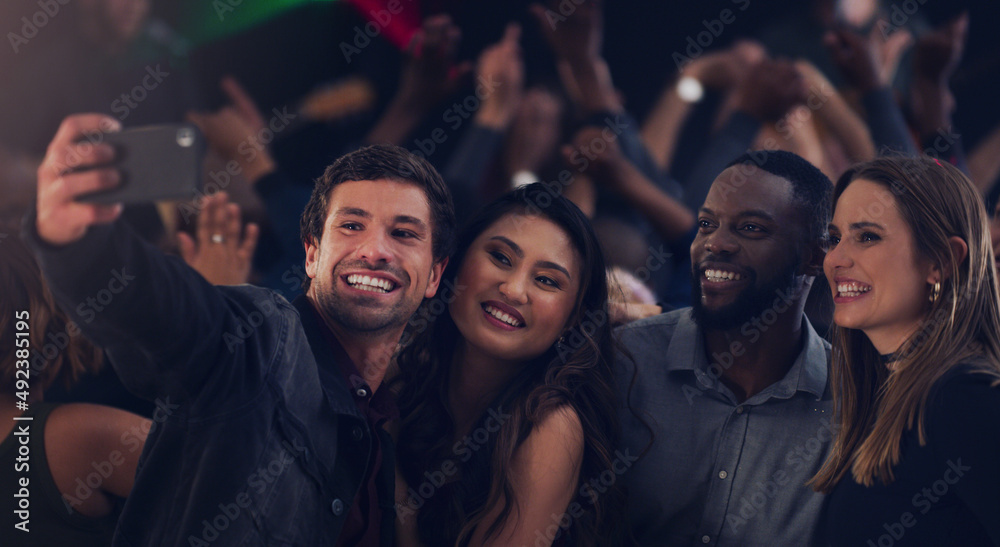 Get in here guys. Cropped shot of a group of young friends taking selfies while dancing together in a nightclub.