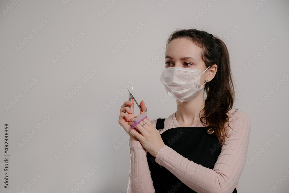 Manicure tools in hands of female manicurist wearing mask Manicure tools in hands of female manicurist wearing mask