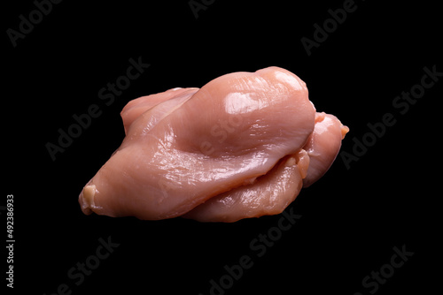 Raw chicken fillet isolated on a black background.