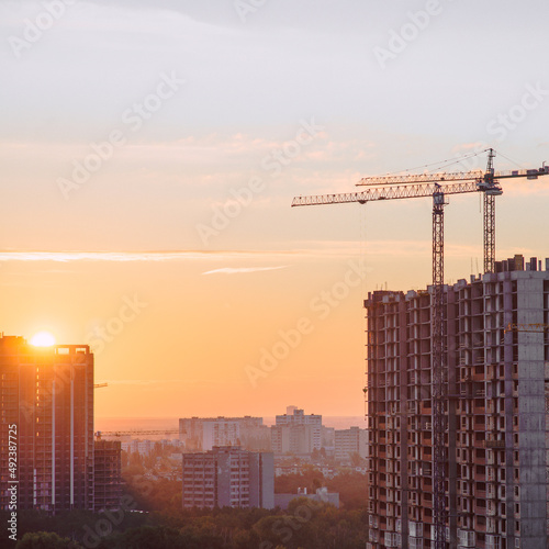 Construction crane building dwelling house at the early morning sunrise time. Kyiv, Ukraine