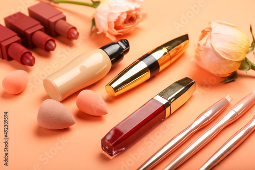 Set of decorative cosmetics with makeup sponges on color background, closeup
