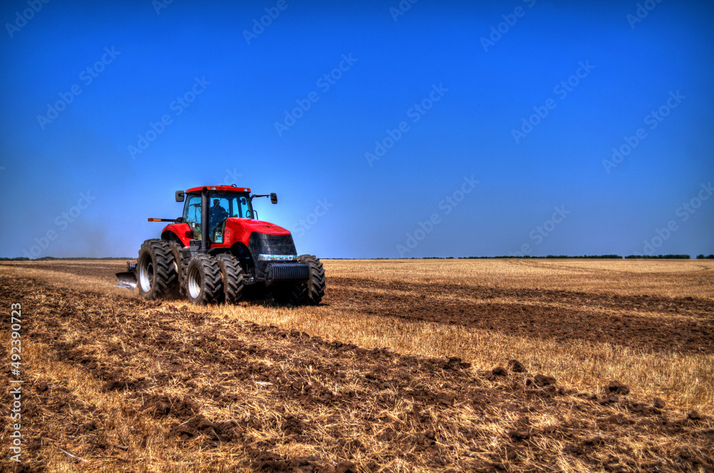 Fototapeta premium Tractor plowing in the field