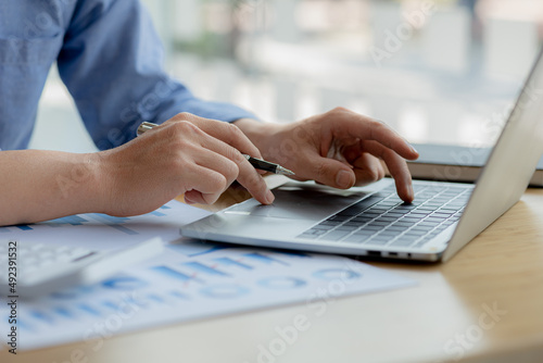 A business man is checking company financial documents and using a laptop to talk to the chief financial officer through a messaging program. Concept of company financial management.