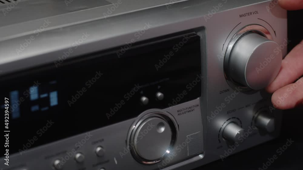 The hand turns the volume control on the music device. Turning down the volume to the minimum The hand turns the volume control on the music device. Turning down the volume to the minimum