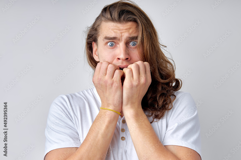 Portrait of shocked surprised man looking at camera, isolated over light gray background. guy in casual wear is emotionally reacts on something, in fear, frightened or shocked by something Portrait of shocked surprised man looking at camera, isolated over light gray background. guy in casual wear is emotionally reacts on something, in fear, frightened or shocked by something