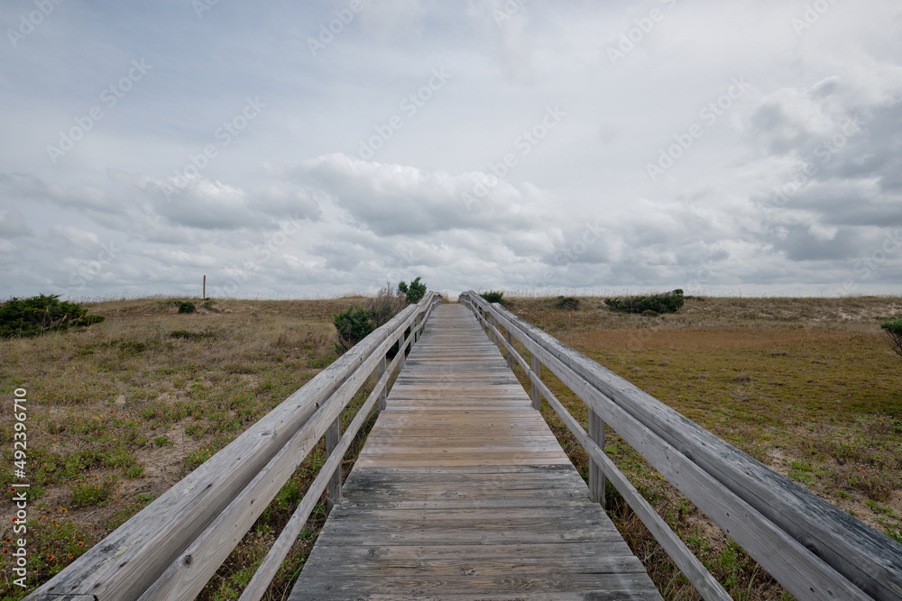 Long wooden deck leading across the dunes to a secluded beach on the Outer Banks of North Carolina