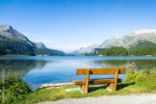 Wooden bench at Lake Sils in summer, Upper Engadin, Switzerland photo