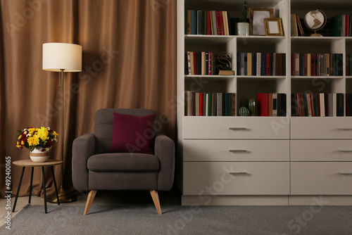 Wallpaper Mural Cozy home library interior with comfortable armchair, floor lamp and collection of books on shelves Torontodigital.ca