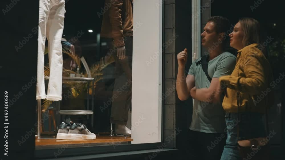 Family looking at the shop window of clothing store.