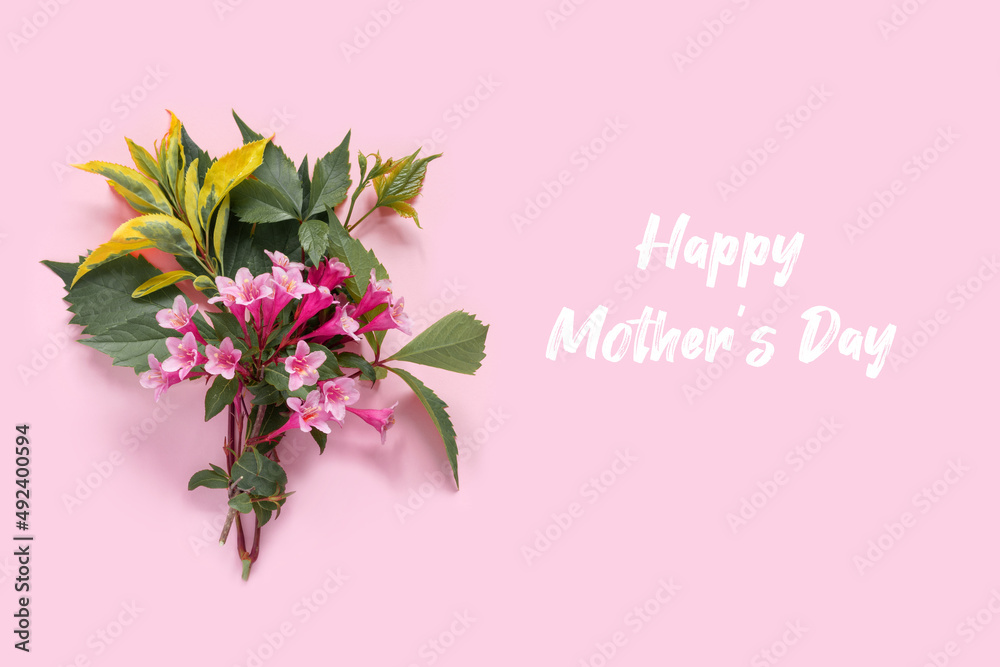 Fototapeta premium Greeting card with pink weigela flowers for mother's day. Creative design with copy space and text.