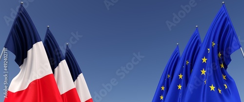 EU and French flags on flagpoles on sides. Flags on a blue background. Place for text. European Union. France flag. Paris. Commonwealth. 3D illustration.