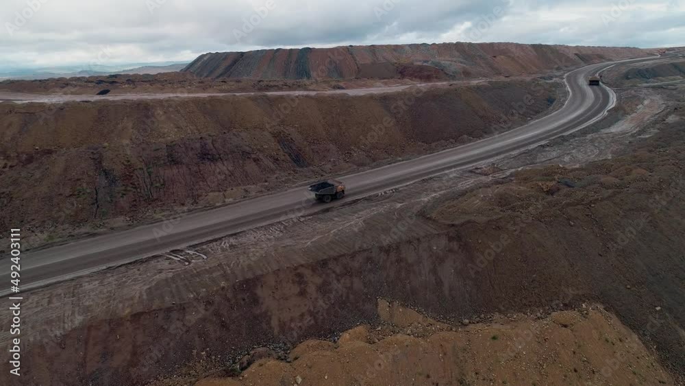 Aerial panoramic view of a coal mining quarry. Heavy mining machinery and dump trucks in a quarry. Aerial panoramic view of a coal mining quarry. Heavy mining machinery and dump trucks in a quarry.